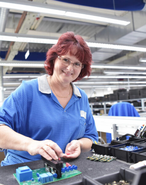 friendly woman working in a microelectronics manufacturing factory - component assembly and soldering